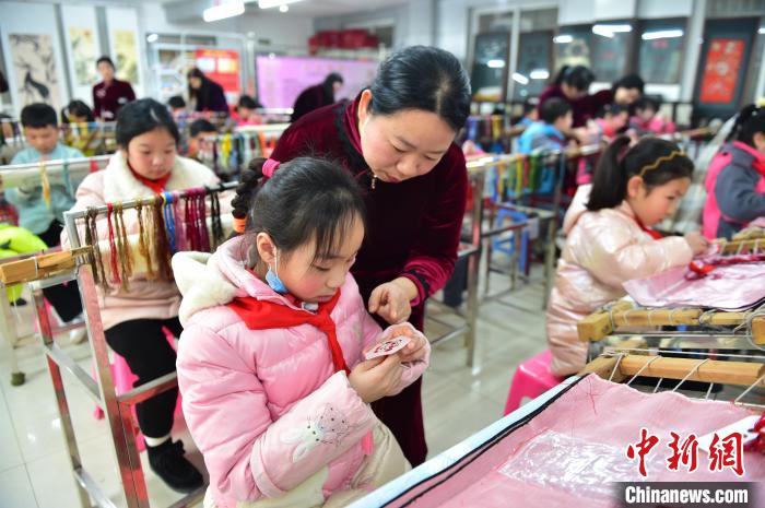江西省級(jí)非遺豫章繡傳承人手把手指導(dǎo)小學(xué)生繡制2022年北京冬奧會(huì)吉祥物“冰墩墩”形象?！∮髟屏?攝