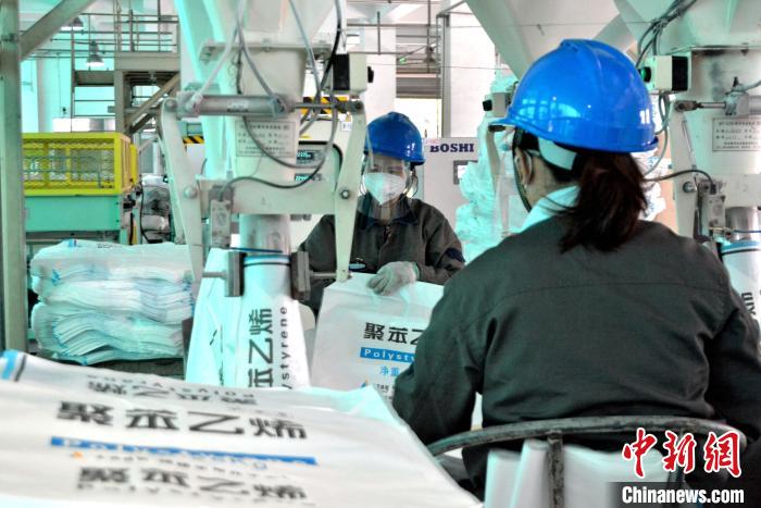 工人在生產(chǎn)線上包裝聚苯乙烯產(chǎn)品?！×趾霔v 攝