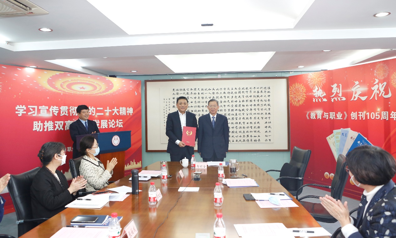 郝明金為《教育與職業(yè)》雜志編委代表陳曉明頒發(fā)聘書(shū)。中華職教社供圖