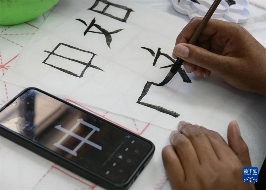 4月18日，肯尼亞學(xué)生在內(nèi)羅畢大學(xué)孔子學(xué)院舉辦的活動(dòng)上寫毛筆字?？夏醽唭?nèi)羅畢大學(xué)孔子學(xué)院18日舉辦“中文，增進(jìn)文明對(duì)話”主題活動(dòng)，慶祝即將到來(lái)的第14個(gè)聯(lián)合國(guó)中文日?？夏醽唽W(xué)生參與互動(dòng)，進(jìn)行書法、剪紙、唱中文歌等活動(dòng)。新華社記者 韓旭 攝