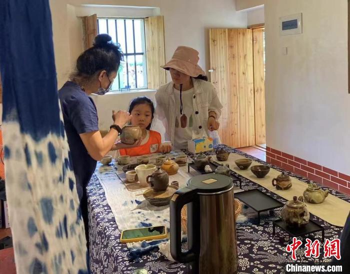 圖為：游客正在咨詢臺(tái)灣柴燒作品。　葉秋云 攝