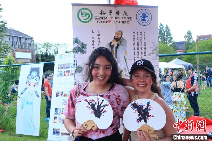 孩子們展示自己的吹墨畫團扇作品?！◆斻肟鬃訉W(xué)院供圖