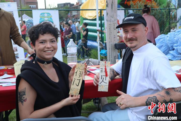 當(dāng)?shù)孛癖娫跐h字體驗工作坊展示自己手寫的中文名書簽。　魯汶孔子學(xué)院供圖