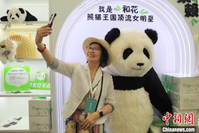 美國華視總裁楊蓮花與大熊貓文創(chuàng)產(chǎn)品合影?！⊥趵?攝