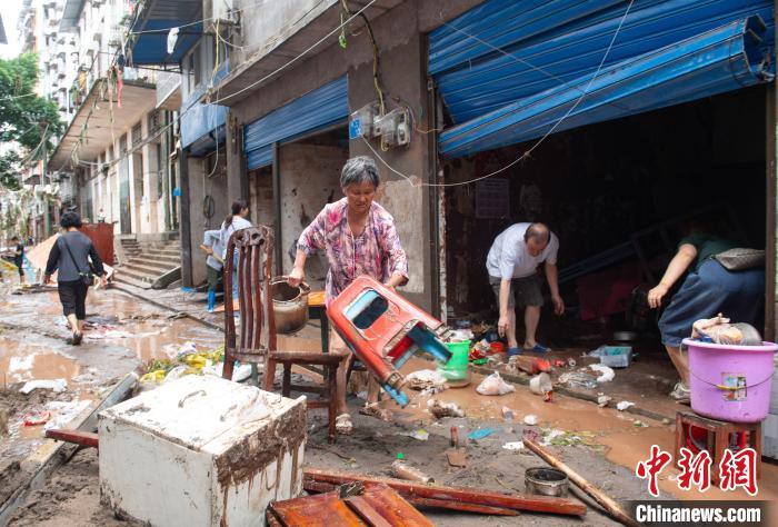 7月4日，萬州區(qū)五橋街道，洪水退去后，居民搶救生活物資?！∪矫宪?攝