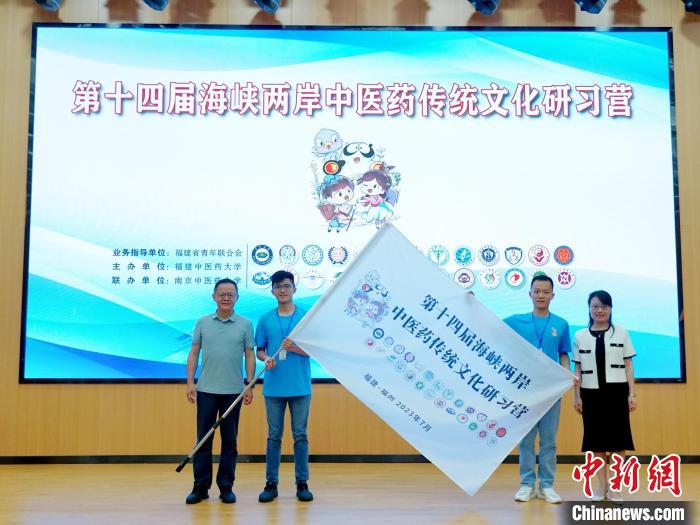 共青團(tuán)福建省委副書記吳雪(右一)、福建中醫(yī)藥大學(xué)黨委副書記林羽(左一)為兩岸學(xué)生代表頒授營旗?！≡S燁婷 攝