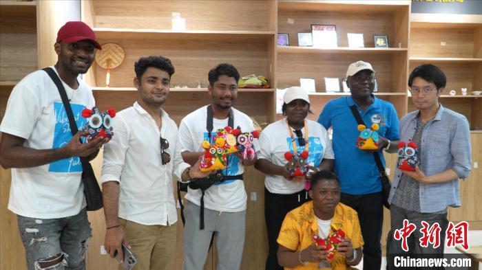 圖為國際青年代表展示親手制作的東營非遺黃河口布偶 ?！↓R魯 攝