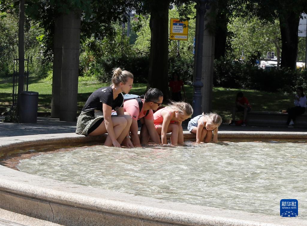 7月8日，人們在德國法蘭克福的一處噴泉玩水。近日，德國法蘭克福逐漸迎來暑熱天氣。新華社記者 張帆 攝