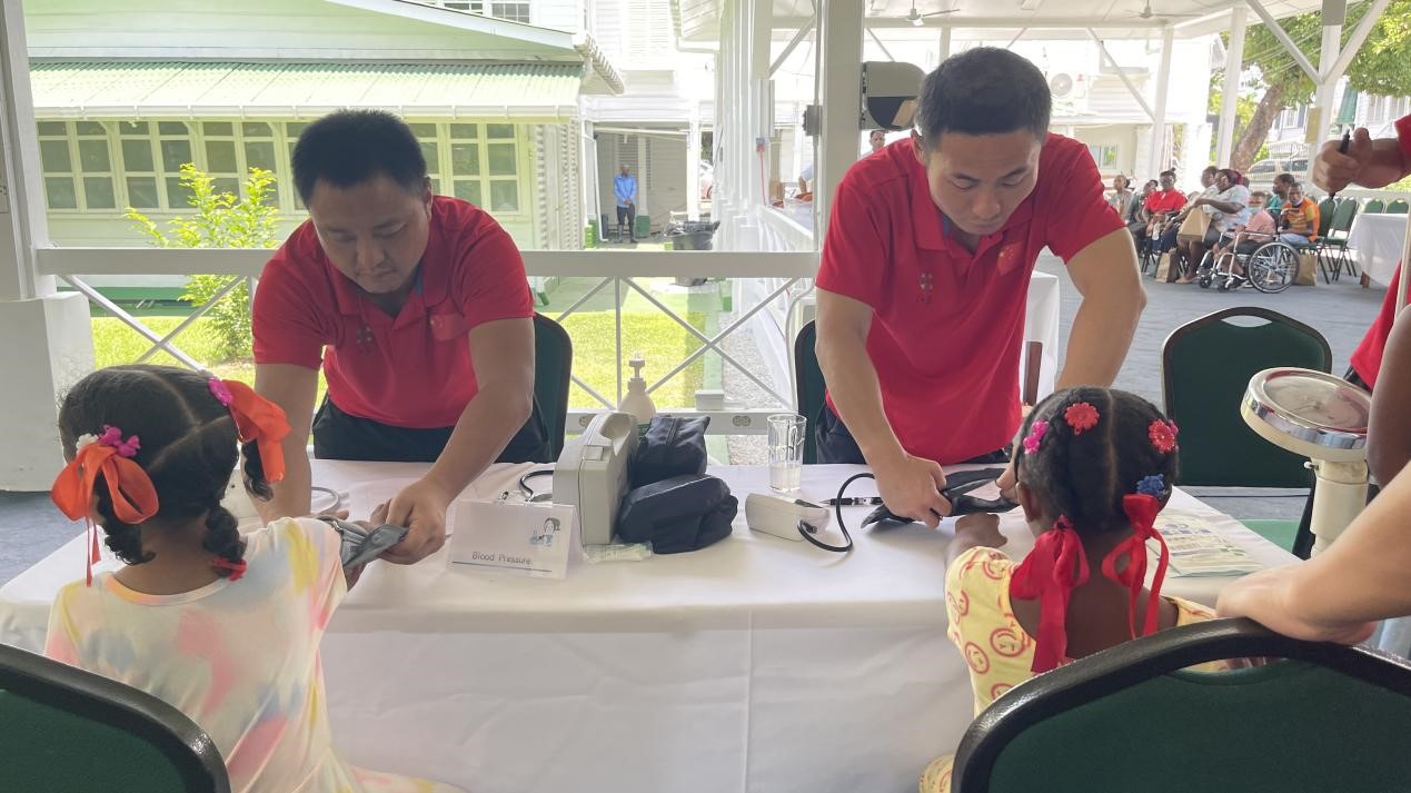 醫(yī)療隊(duì)員為福利院兒童進(jìn)行檢查。第18期援圭亞那醫(yī)療隊(duì)供圖