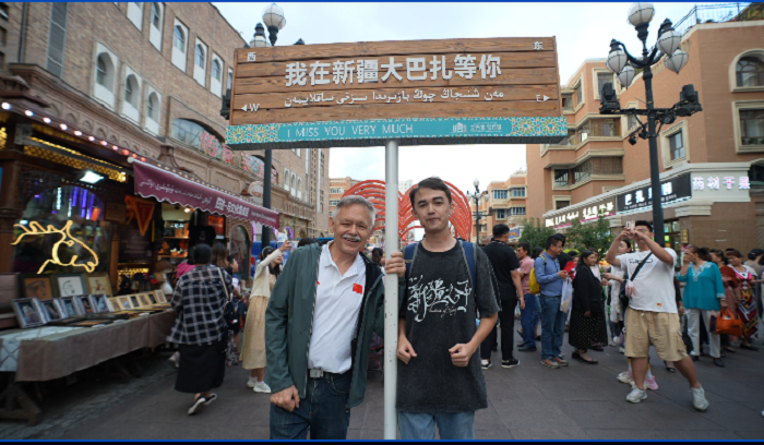 潘維廉和維吾爾族青年伊木蘭“打卡”大巴扎。主辦方供圖