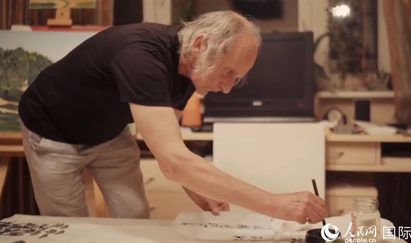 伊戈?duì)枴げ紶枛|諾夫在畫作上題詞。人民網(wǎng)記者 馬天翼攝