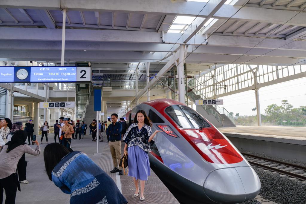 10月17日，在印度尼西亞萬隆德卡魯爾站，乘客在站臺上和雅萬高鐵高速動車組列車合影。
