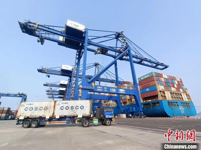 圖為海南洋浦國際集裝箱碼頭，卡車將集裝箱從后方堆場運往碼頭裝卸區(qū)?！堅潞?攝