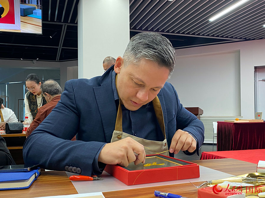 2023“一帶一路”媒體合作論壇聯(lián)合采訪團(tuán)團(tuán)員，親身體驗(yàn)景泰藍(lán)工藝。人民網(wǎng)記者 于洋攝