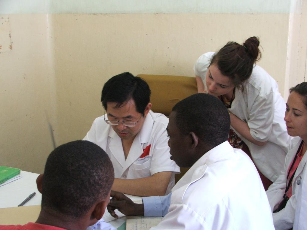 2011年7月22日，在坦桑尼亞桑給巴爾納茲莫加醫(yī)院外科門診，中國第24批援桑給巴爾醫(yī)療隊隊長盧建林為當(dāng)?shù)鼗颊咴\治并帶教實習(xí)生。新華社發(fā)（國家衛(wèi)生健康委供圖）