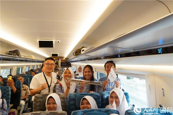 第一次乘坐雅萬(wàn)高鐵動(dòng)車(chē)組的學(xué)生們與動(dòng)車(chē)組模型合影。人民網(wǎng)記者曹師韻攝