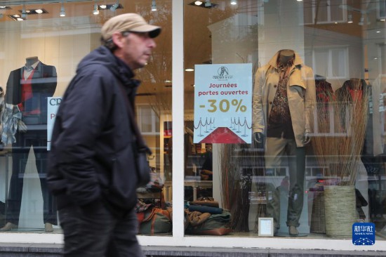   10月31日，一名男子從比利時(shí)布魯塞爾一家貼有打折信息的店鋪前走過。新華社記者 趙丁喆 攝