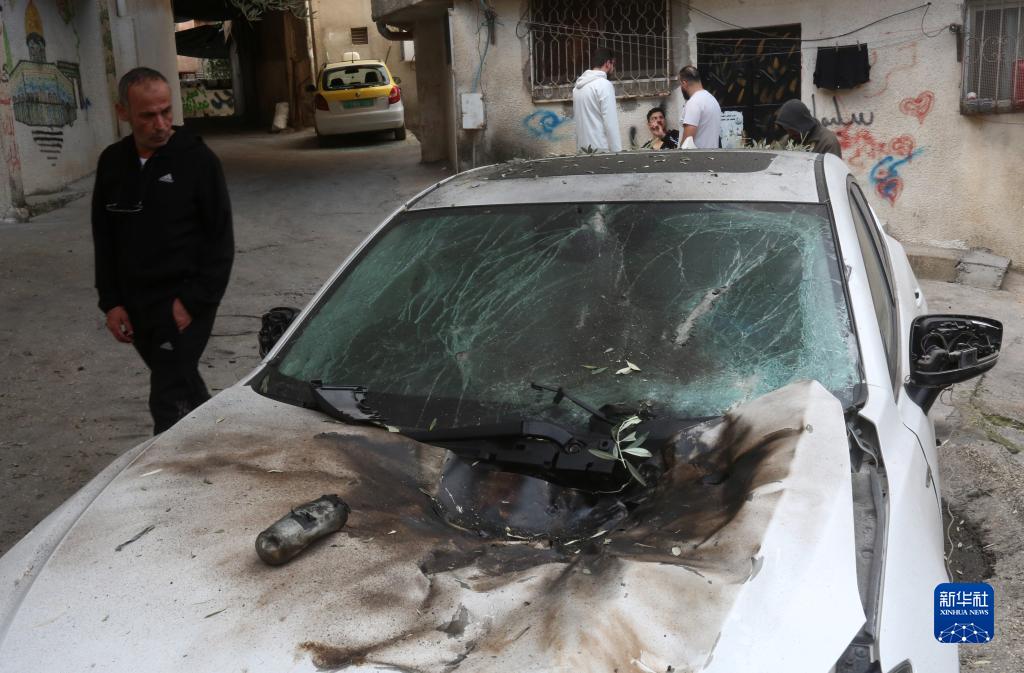 12月17日，在約旦河西岸城市圖勒凱爾姆附近的一處難民營(yíng)，人們查看在沖突中損毀的車輛。新華社發(fā)（尼達(dá)爾·艾仕塔耶?dāng)z）