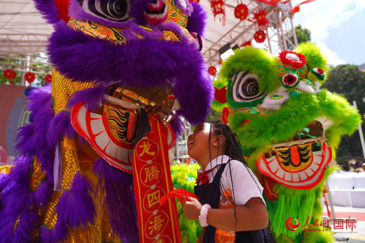 小朋友與舞獅表演者互動(dòng)。人民網(wǎng)記者 黃煒鑫攝