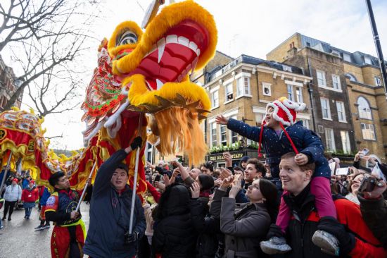 2月11日，人們在英國倫敦的新春巡游活動中觀看舞龍表演。新華社發(fā)（史蒂芬·程攝）