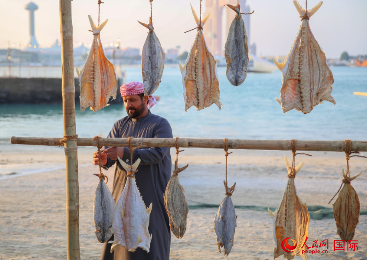    手工藝者展示如何晾曬魚干。人民網(wǎng) 塔里克·易卜拉欣攝