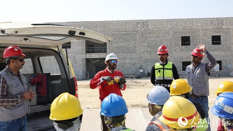 穆薩瓦爾(圖中紅衣人）現(xiàn)場演示工具操作規(guī)范。人民網記者 管克江攝