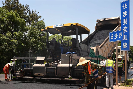 工人正在進行“極薄磨耗層”路面的鋪筑。受訪單位供圖