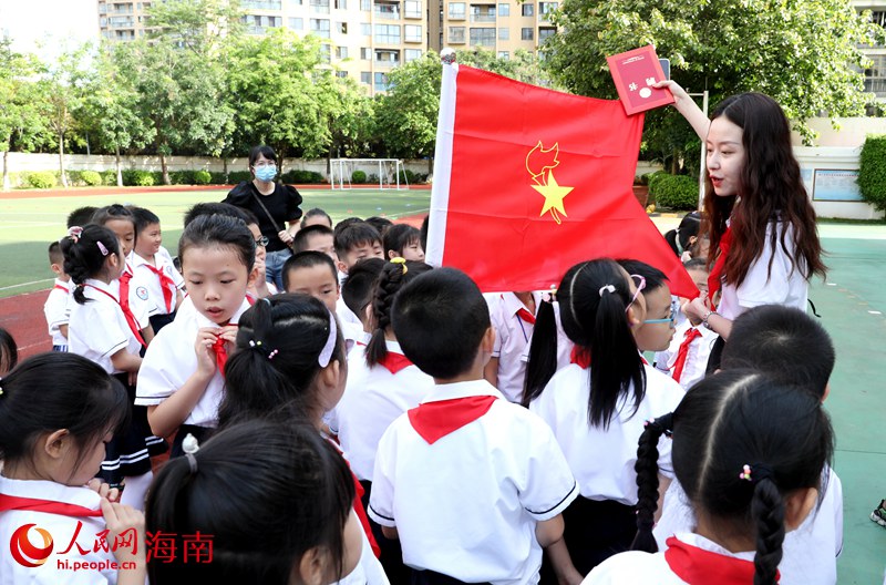 老師向少先隊員展示隊旗。人民網 符武平攝