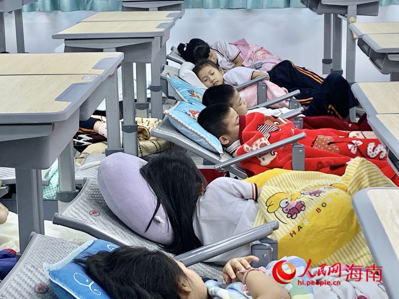 海口第二十六小學(xué)學(xué)生在新式課桌椅上午休。人民網(wǎng) 李浩蓉?cái)z