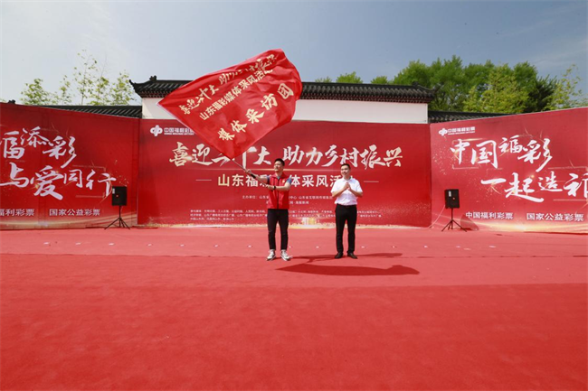 為媒體采風(fēng)團(tuán)授旗。 山東省福彩供圖