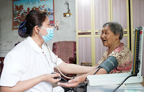 護(hù)理團(tuán)隊(duì)醫(yī)生為老人測(cè)量血壓。 陳佳兵攝