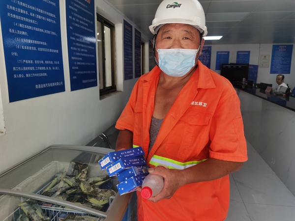 1環(huán)衛(wèi)工倪建宏小憩后，為還同事帶去冷飲。人民網(wǎng)記者王繼亮攝