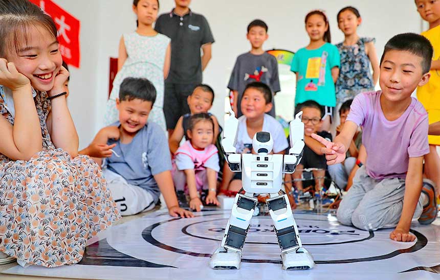 2022年7月19日，河北省秦皇島市海港區(qū)白塔嶺街道秦皇半島第二社區(qū)內，小朋友正在觀看“機器人跳舞”。 曹建雄攝