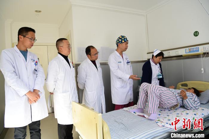 圖為何蔚副主任醫(yī)師(站右二)及團隊術(shù)后指導(dǎo)患者進行腰背肌鍛煉?！∝暩聛硭?攝