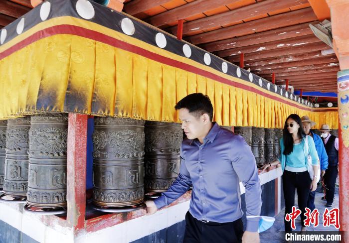 圖為外籍嘉賓體驗藏族傳統(tǒng)轉(zhuǎn)經(jīng)筒?！●R銘言 攝