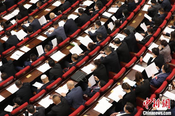 圖為會議現(xiàn)場，參會代表正在聽取政府工作報告?！∑钤鲚?攝