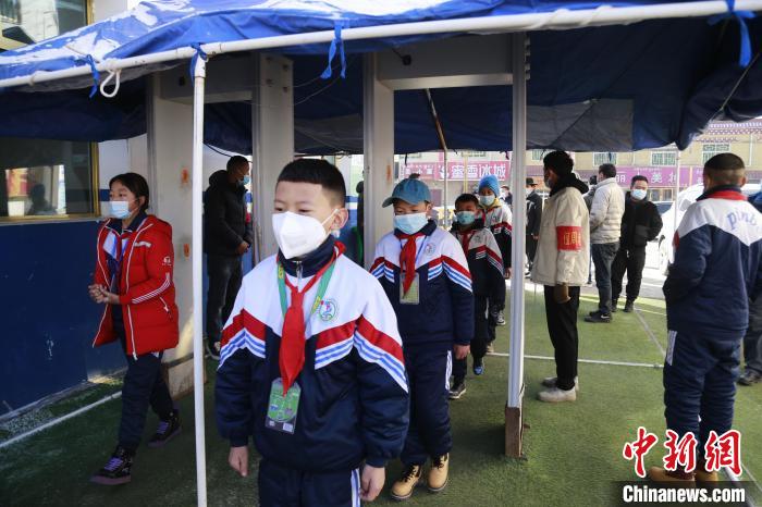 圖為學(xué)生測量體溫后進(jìn)入校園。　馬銘言 攝