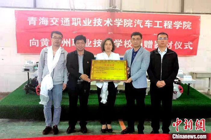 圖為李富香(中)代表學(xué)校為州縣技校捐贈(zèng)器材。(資料圖) 青海省教育廳供圖