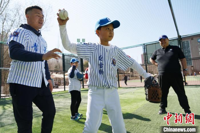 圖為教練指導小棒球手擲球技術(shù)?！●R銘言 攝