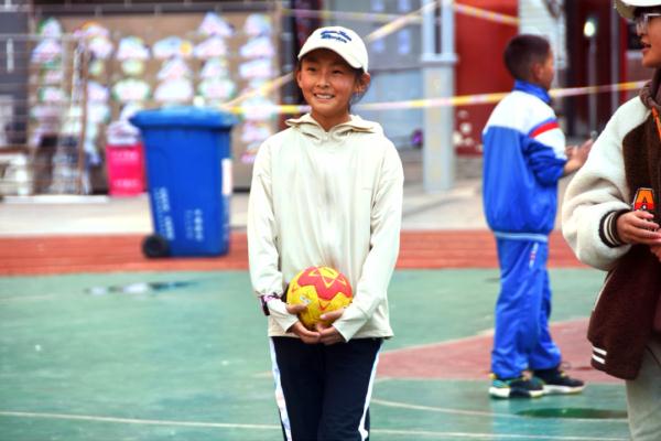 在高原上教孩子們打手球，“慢慢兒來(lái)，甭著急！”