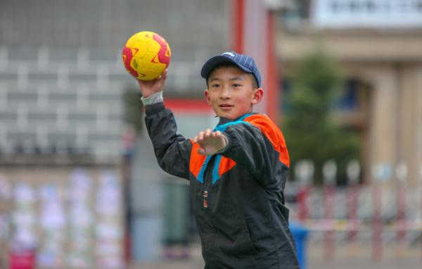 在高原上教孩子們打手球，“慢慢兒來(lái)，甭著急！”