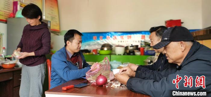 圖為扶貧路上“臨時一家人”準(zhǔn)備午餐。　魏建軍 攝