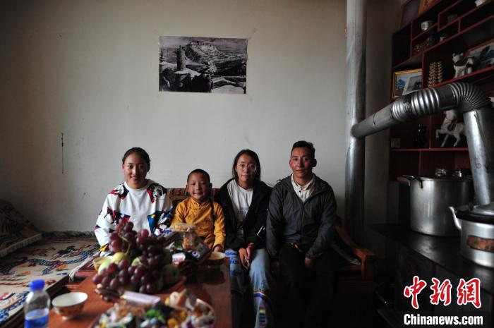 圖為8月12日，2018年7月從距那曲市色尼區(qū)城區(qū)那曲鎮(zhèn)90千米外的古露鎮(zhèn)當桑村搬遷至城區(qū)的旦增(右一)與家人在80多平方米的新家合影(資料圖)?！垈?攝