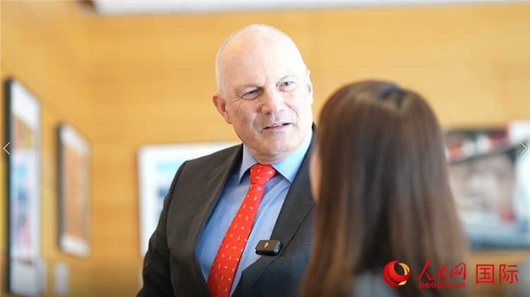 瑞士駐華大使白瑞誼介紹使館內陳列的照片。人民網(wǎng) 彭昱凱攝