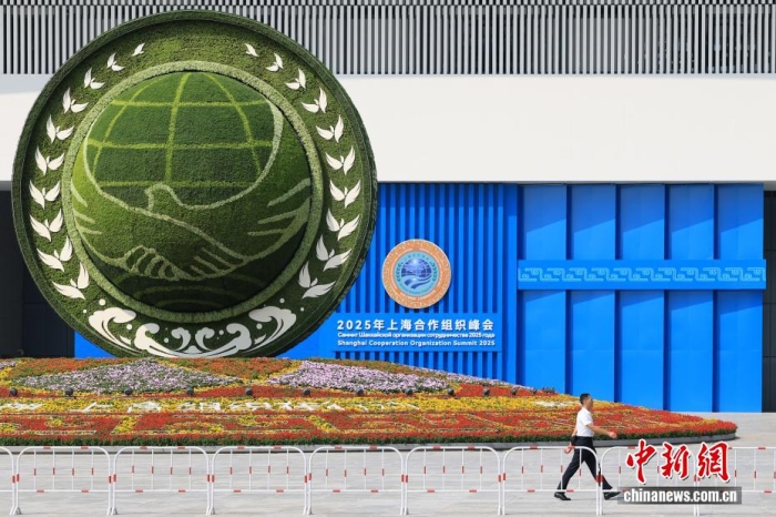 8月31日，天津，一名工作人員從2025年上海合作組織峰會主會場外的景觀花壇旁經(jīng)過。當(dāng)日，2025年上海合作組織峰會在天津舉行。<a target='_blank' href='/'><p  align=