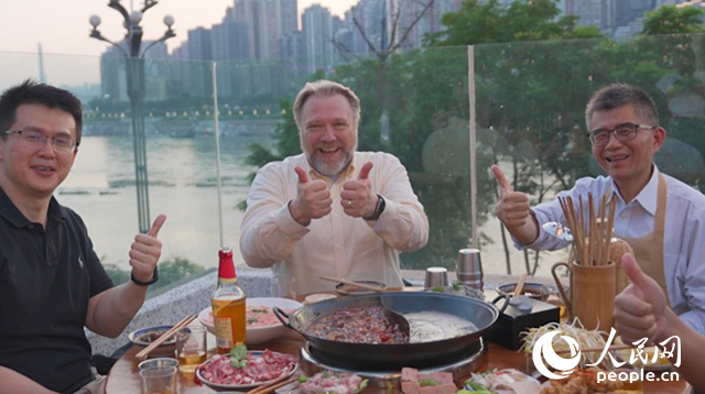 康寧顯示科技事業(yè)部全球拓建項目總監(jiān)軻寶華（中）和同事在重慶南濱路吃火鍋。人民網(wǎng)記者 蘇纓翔攝
