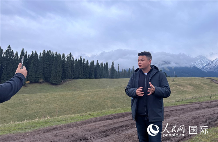 在庫爾德寧，吾買爾江被雪山美景震撼，即興錄制了短視頻作品。人民網(wǎng)記者曾書柔攝