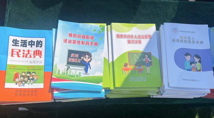 有關部門分發(fā)的普法宣傳冊。人民網 高清揚攝