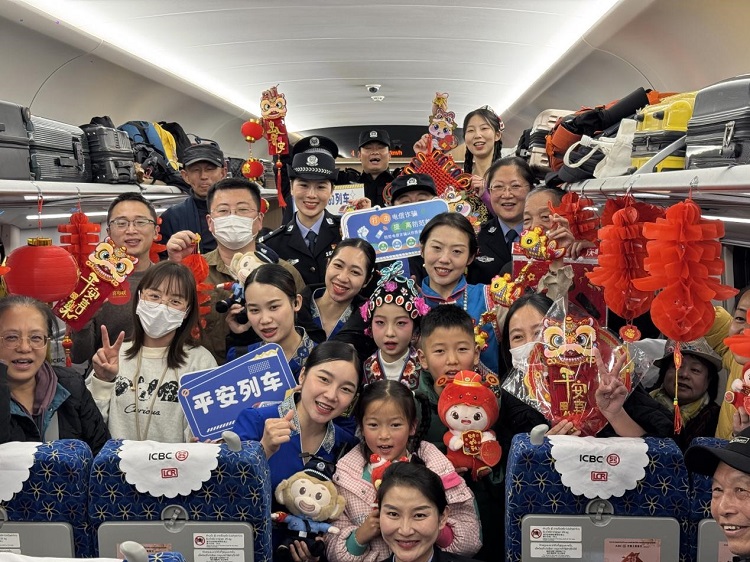 春節(jié)期間，在中老鐵路磨萬（磨丁—萬象）段，鐵路客運員工與乘客合影留念。李加勇攝