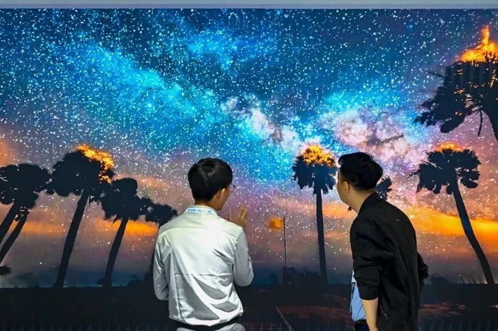 長(zhǎng)春光博會(huì)希達(dá)電子展區(qū)，一位工作人員正在給一位觀眾講解。（長(zhǎng)春新區(qū)供圖）